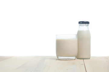 Milk in glass and in jar on table isolated on white background