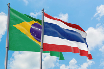 Thailand and Brazil flags waving in the wind against white cloudy blue sky together. Diplomacy concept, international relations.