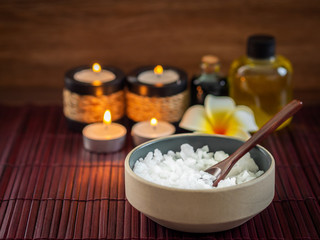Fototapeta na wymiar Spa pure mineral sea salts with bottles of massage oil and aromatheray candles (Thai style)