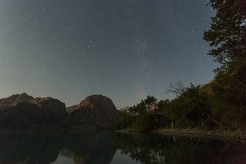 astrophotography of a night starry sky with a milky way over a lake