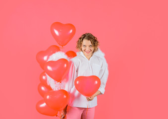 St Valentine day. Sexy woman dressed as angel with red balloons. Love story concept. Female angel. Valentines day. Cupid with heart shaped balloons. Happy woman with angel wings holds heart balloons.