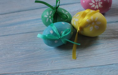 Painted Easter eggs lie on a blue wooden table.