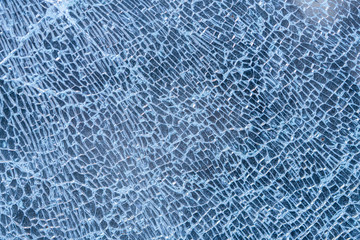broken glass background. a glass window cracked with cobwebs. abstraction