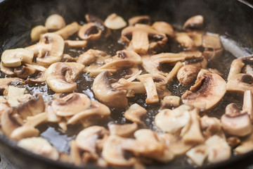 Fried mushrooms in a pan. Cooking mushrooms with steam emanating from them.