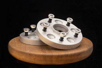 Automotive parts - close up new stainless metal remote adapter spacer wheel hub of the car on black...