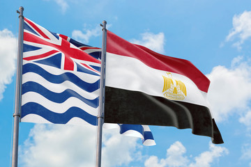 Egypt and British Indian Ocean Territory flags waving in the wind against white cloudy blue sky together. Diplomacy concept, international relations.