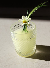 delicious drink with citrus fruits in a glass with field flowers