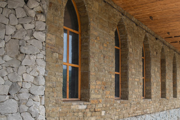 The facade of the building is made of stone. Exterior decoration of stone and clay. Windows are inserted and there is a roof.
