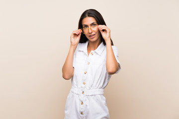 Young woman over isolated background with glasses and surprised