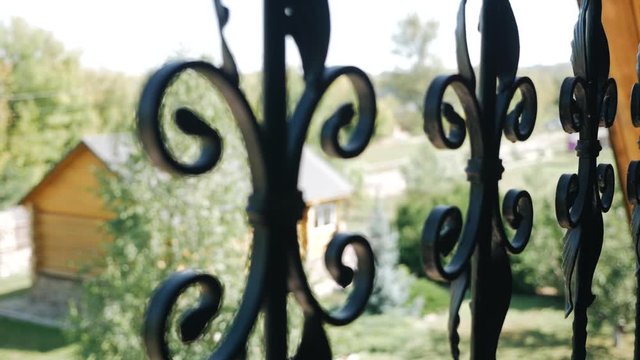Shot of of a beautiful decorative cast iron wrought fence with artistic forging. Metal guardrail silhouette