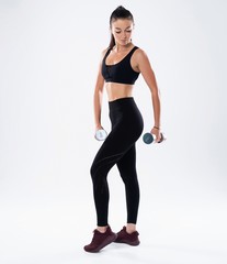 Fototapeta na wymiar beautiful sporty muscular woman working out with two dumbbells