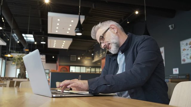 Salesman in restaurant working on laptop computer