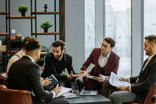 young handsome guys in tux hold meeting in office, successful people discuss strategies, projects and ideas. business coworking in conference room