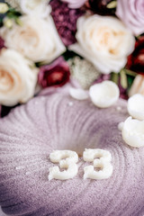 Fototapeta na wymiar Lilac mousse cake for thirty-three years. White chocolate numbers. Number 33. Cake and a bouquet of flowers. Lilac bouquet with white roses. Birthday cake.