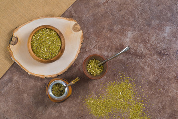 Flat lay yerba mate tea in porongo, in calabash and in wooden bowl