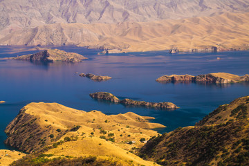 Beautiful blue waters of Nurek reservoir and golden shores