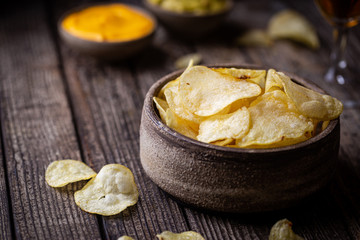 Crunchy delicious potato chips for a tasty snack break on dark rustic background