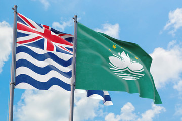 Macao and British Indian Ocean Territory flags waving in the wind against white cloudy blue sky together. Diplomacy concept, international relations.