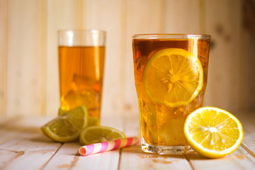 Glasses of ice tea with lemon slices  on wooden background