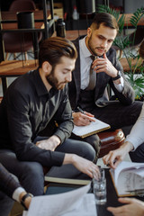 friendly and successful business crew coworking in office, gathered to discuss and share opinions about business strategy, cooperation of young leaders, business partners in tuxedo