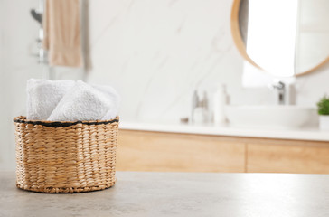 Fototapeta na wymiar Rolled fresh towels on grey table in bathroom. Space for text