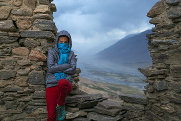 A girl on the walls of a ruined ancient fortress at the valley of the Pyandzh River on the border with Avganistan