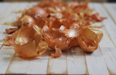 The use of onion skins in medicine and for coloring Easter eggs. Onion skin and onion on a wooden background.