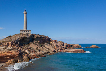 Cabo de Palos Lighthouse on the blue sky background, located on a small peninsula in Cartagena, Murcia, Spain