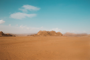 Fototapeta na wymiar Sand dunes in Wadi RAM in the morning, Jordan.Pink sand in the desert. the mountains are located in the wasteland.Blue sky and beautiful weather for traveling through the beauty of red sand.Bedouin's