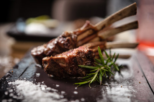 Grilled lamb chops served with a branch of rosemary