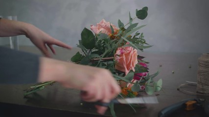 design floral, professional female florist works in a floristic store and makes a bouquet of flowers ties it with twine, small business