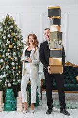 couple dressed in formal elegant costumes with gift boxes in their hands