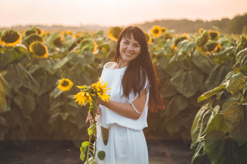 Beautiful young woman in a sunflower field. Portrait of a young woman in the sun. Pollen allergies...