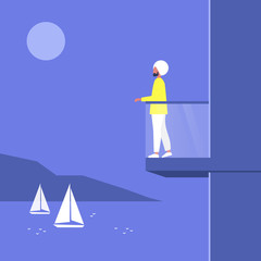 Obraz premium Young indian male character standing at the balcony and looking at the sea view, luxury apartment, real estate