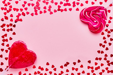 Valentines Day card. Two lollipops candy heart shape on pink background. Copy space, top view.