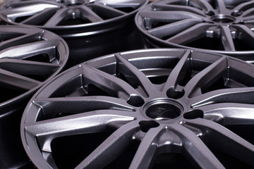 Modern automotive alloy wheel made of aluminum on a black background, industry. Designer fashion...