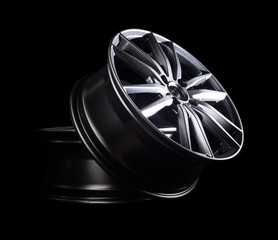 Modern automotive alloy wheel made of aluminum on a black background, industry. Designer fashion...
