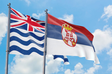 Serbia and British Indian Ocean Territory flags waving in the wind against white cloudy blue sky together. Diplomacy concept, international relations.
