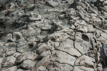 Texture of the surface covered with lava stones. Stony soil in natural shades of gray. Stones cut with water.