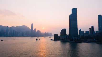Fototapeta premium Aerial scenery panoramic view of Hong Kong Evening with metropolitan bay Victoria Harbor at sunset. Lighted Modern cityscape, urban skyline buildings. Energy power infrastructure. Popular Asian city