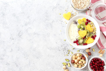 Healthy breakfast with yogurt, granola, fresh fruits and nuts on white background. Top view with copy space. Healthy eating.