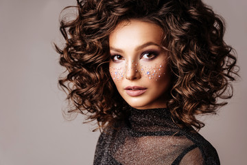 Fototapeta premium Portrait of Beautiful Woman with Sparkles on her Face. Fashion Model with Colorful Makeup