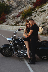 Plakat Portrait of beautiful young couple on a motorcycle. Attractive young woman with handsome young man on motorbike.