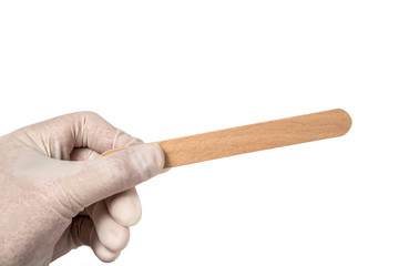 hands hold a sterile disposable eco friendly wooden medical spatula designed for examining the mouth and throat on a white isolated background