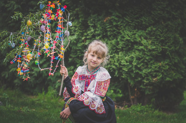 Easter traditional folk costume complimenting on Easter with colorful eggs hang on green branch