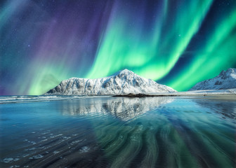 Aurora Borealis, Northern Lights Above on snowy mountain in Skagsanden Beach at Lofoten Islands © Mumemories