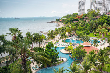 Scenery of Luxury resort surrounding green garden with swimming pool on coastline in tropical sea