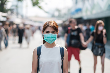 Fototapeta na wymiar young Asian woman wearing protection mask against Novel coronavirus (2019-nCoV) or Wuhan coronavirus at Chatuchak Weekend Market, landmark and popular for tourists attractions in Bangkok, Thailand