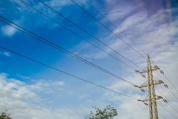 High voltage electric transmission pylon silhouetted. Electricity transmission pylon silhouetted against blue sky. High voltage electric tower in the blue sky background, side view.