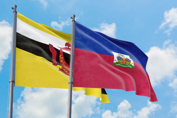 Haiti and Brunei flags waving in the wind against white cloudy blue sky together. Diplomacy concept, international relations.
